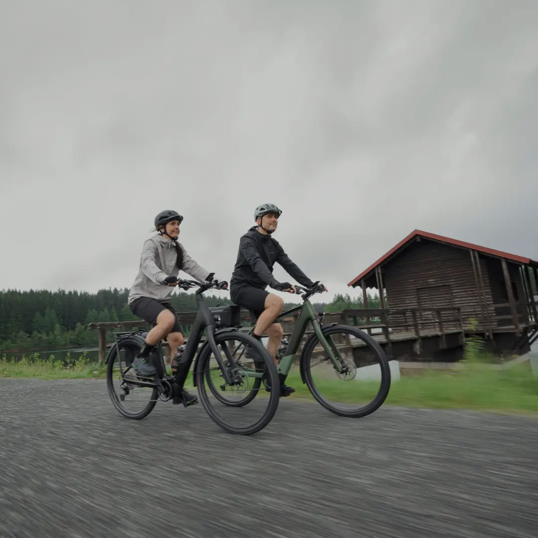Mann und Frau auf Ihren E-MTBs auf einem Schotterweg