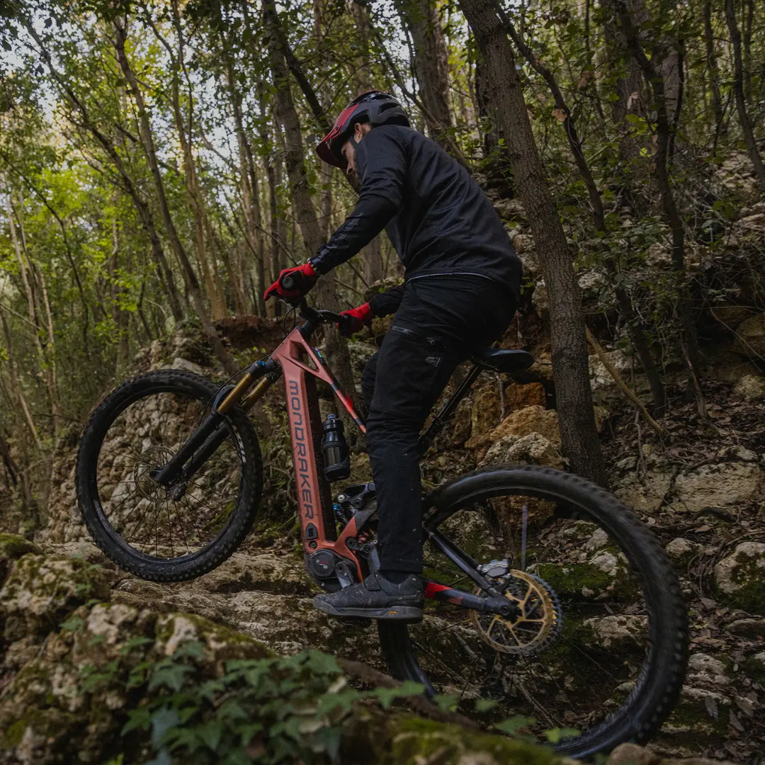 Person auf einem Fully fährt im Gelände